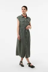 Vestido camisero midi sin mangas color verde militar, confeccionado en lino, con botones frontales, bolsillos en el pecho y cintura ajustable con cordón.