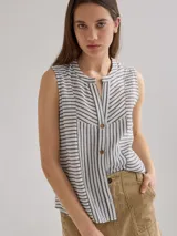 Camisa sin mangas a rayas verticales blancas y grises, con cuello mao y cierre parcial con botones.