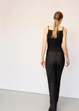 Jeans de denim negro de tiro bajo y corte recto, con presillas para cinto y bolsillos funcionales.