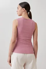 Top sin mangas de tejido canalé en color rosa pastel, con cuello redondo ajustado.