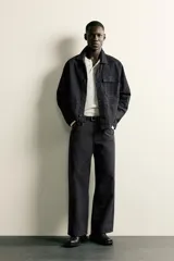 Jeans de corte relajado y pierna recta, confeccionados en denim de algodón rígido. Presentan tiro medio, cierre frontal con cremallera y botón, y diseño clásico de cinco bolsillos.