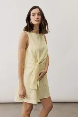 Vestido corto sin mangas de color amarillo claro, con cuello redondo y detalle de nudo drapeado en el frente.