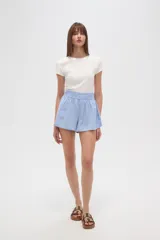 Short de calce alto y corte holgado, confeccionado en tela de viscosa color celeste, con cintura elástica fruncida.