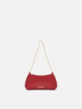 Cartera Le Petit Bisou Chaine de Jacquemus de cuero rojo, con silueta curva, correa de cadena dorada y logotipo metálico frontal.