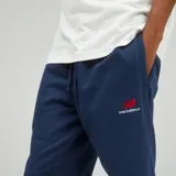 Pantalón de jogging azul marino de felpa francesa, con cintura y puños elásticos, cordón plano de algodón y logo bordado en rojo en el muslo izquierdo.