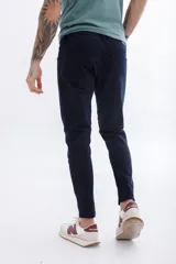 Pantalón de jean azul oscuro, corte skinny, tiro medio y cinco bolsillos.