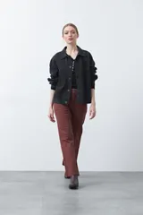 Remera de manga larga color beige, confeccionada en algodón, con escote en V y cartera corta de botones blancos.