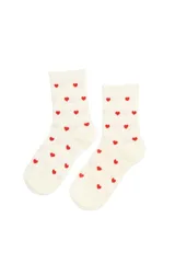 Par de medias de caña media con tejido acanalado, color crema con estampado de corazones rojos pequeños.