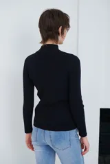 Polera de tejido morley color azul, con cuello alto y mangas largas, de corte ajustado al cuerpo.