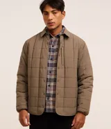 Campera capitoneada Blue Steel de color marrón, con cuello polo, manga larga, puños ajustados, cierre frontal con botones a presión y un bolsillo vertical en el pecho.