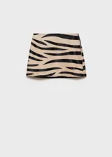 Falda corta de tiro medio con estampado animal print de cebra. Presenta un diseño recto y cierre de cremallera lateral.