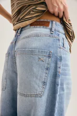 Jean slouchy de tiro alto en color celeste con lavado claro, corte amplio tipo barrel y diseño de perneras curvadas que se estrechan en los tobillos.