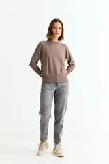 Sweater de punto liso color marrón topo, con cuello redondo y manga larga. Presenta un detalle de tres botones pequeños en la abertura del puño.