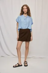 Short cruzado de tiro medio con diseño frontal tipo falda, color negro, de líneas simples y calce cómodo.
