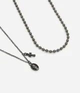 Conjunto de dos collares de metal color gris oscuro. Uno es una cadena fina con colgantes de medalla oval con figura sacra en relieve y una cruz pequeña. El otro es una cadena de bolitas.