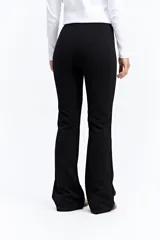 Pantalón de tiro medio con calce ajustado en la parte superior y leve apertura en el bajo, estilo bootcut.
