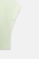 Camiseta cropped color verde menta, con cuello redondo y mangas cortas amplias con dobladillo.