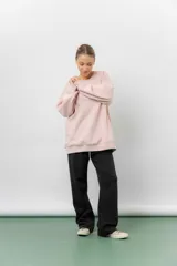 Buzo oversize de cuello redondo, confeccionado en algodón suave con interior frizado. Presenta un diseño de líneas simples, corte relajado y mangas largas con puños ajustados.