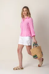 Camisa color coral de lino con cuello clásico, manga 3/4 y cierre frontal con botones.