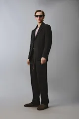 Blazer de corte regular confeccionado en lino, con solapas de muesca, cierre frontal de botones y múltiples bolsillos con solapa en la parte frontal. Presenta un diseño estructurado con abertura en la espalda y forro parcial.