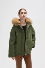 Campera negra de algodón con capucha, cierre frontal oculto y bolsillos laterales. Presenta un diseño holgado con detalles de piel sintética en el borde de la capucha.