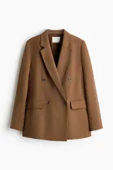 Blazer color marrón levemente largo con solapas de muesca, hombreras y doble botonadura frontal. Cuenta con bolsillos delanteros ribeteados con solapa y diseño forrado.