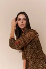 Camisa de gasa con estampado animal print de cebra, mangas largas abullonadas con puños elásticos y logo bordado en rojo en el puño.