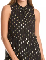 Vestido midi negro de gasa con estampado de lurex dorado, sin mangas y cuello alto. Presenta cintura elastizada, falda con volumen y movimiento, y abertura tipo gota con botón en la espalda. Incluye forro interno a tono.