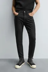 Jeans de hombre, corte skinny y largo cropped, color negro lavado. Presenta cinco bolsillos y cierre frontal con cremallera y botón.
