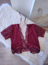 Conjunto de lencería compuesto por un top de encaje y microtul con mangas cortas y escote profundo, y una bombacha tipo hipster de tiro alto confeccionada en encaje con refuerzo de algodón.