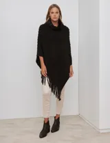 Poncho tejido negro con textura, cuello alto de velour negro y terminación con flecos largos en el ruedo.