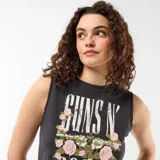 Musculosa negra de corte crop, con cuello redondo y diseño sin mangas. Presenta un estampado frontal con la inscripción "Guns N' Roses" en efecto desgastado, acompañado de pistolas y rosas rosadas.