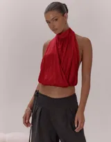 Top halter color rojo con cuello alto, diseño cruzado en el frente y espalda descubierta.