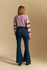 Jean oxford de tiro alto confeccionado en denim con spandex, de color gris oscuro lavado. Presenta un corte ajustado en la parte superior que se ensancha hacia el ruedo, el cual incluye aberturas frontales.