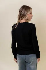 Buzo de punto color beige melange, de manga larga, cuello redondo y corte recto.