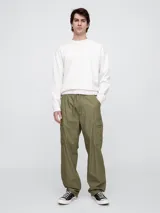 Pantalón cargo de corte holgado en color verde oliva, confeccionado en popelina. Presenta cintura elástica con cordón ajustable, bolsillos laterales tipo cargo y diseño de pierna ancha.