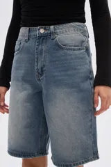 Bermuda de jean estilo boyfriend, color gris lavado, de tiro alto con bolsillos laterales y traseros, y largo a la rodilla.