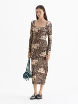 Vestido midi de punto con estampado animal print, escote cuadrado, mangas largas y tajo lateral. Presenta un calce ajustado al cuerpo y logo bordado en la espalda.