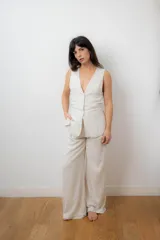 Chaleco sastrero color crudo, con escote en V y cierre frontal con botones.