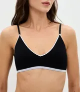 Soutien tipo bralette de diseño seamless en color marrón oscuro, con ribetes en contraste color blanco y banda inferior en color lila. Presenta copas desmontables y breteles finos ajustables.