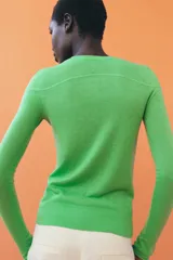 Jersey de punto fino con diseño color block en tonos rojo, bordó y blanco. Presenta cuello redondo y manga larga.