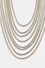 Cinturón plateado con múltiples eslabones y anillas metálicas. Cierre con mosquetón.