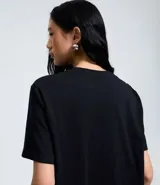 Remera de algodón color negro con cuello redondo y mangas cortas. Presenta un estampado gráfico frontal de la artista Jennie con diseño detallado.