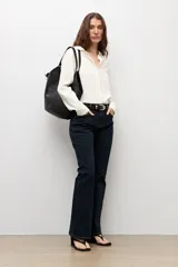 Camisa clásica de color blanco off-white, confeccionada en tejido ligero y fluído, con cuello solapa, cierre frontal abotonado y mangas largas con puños abotonados.