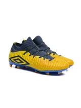 Championes de fútbol Umbro modelo Ignis HG, con diseño de botín de corte medio en color amarillo con detalles en azul marino y suela azul con tapones naranjas.
