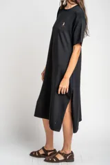 Vestido midi de punto negro con pequeño bordado de un velero en el pecho, mangas cortas y tajo lateral en el dobladillo.