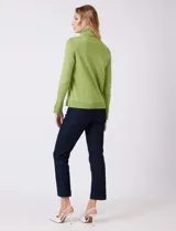 Polera de tejido fino, color rosado, con cuello alto, manga larga y detalle de tajo en los puños.