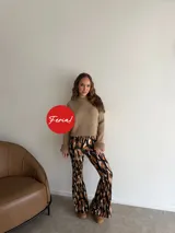 Pantalón estilo oxford confeccionado en viscosa, con tiro alto y diseño ajustado en las piernas que se ensancha hacia el dobladillo. Presenta un estampado abstracto en tonos marrones, negros y blancos.