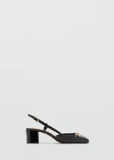 Zapato de charol negro con tacón bloque, punta cuadrada, cierre con hebilla y detalle de eslabones dorados.