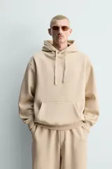 Sudadera con capucha de corte relajado, confeccionada en tejido de algodón con interior perchado. Presenta mangas largas, bolsillo frontal tipo canguro y terminaciones en rib.
